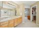 Bright main bathroom with double vanity, separate shower, soaking tub, and walk-in closet at 10115 Cook St, Thornton, CO 80229