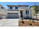 Two story home with gray stone accents, gray siding, large windows, a gray garage door, and landscaping at 455 S Salida St, Aurora, CO 80017