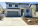 Two-story home with grey siding, stone accents, concrete driveway, and attached two-car garage at 455 S Salida St, Aurora, CO 80017