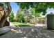 Gravel and grass backyard with shed and mature trees at 7642 S Ames Way, Littleton, CO 80128
