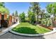 Spacious backyard with lush lawn, mature trees, and exterior home view at 7642 S Ames Way, Littleton, CO 80128