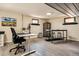 Bright basement area features a modern desk setup and a bar area with stools for entertaining at 7642 S Ames Way, Littleton, CO 80128