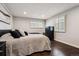 Bedroom with hardwood floors and bright natural lighting from windows at 7642 S Ames Way, Littleton, CO 80128