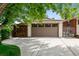 A spacious garage with a multi-paned garage door and concrete driveway at 7642 S Ames Way, Littleton, CO 80128