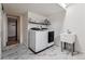 Practical laundry room with modern appliances, sink, and stylish marble tile flooring at 7642 S Ames Way, Littleton, CO 80128