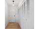 Hallway featuring wood floors, a closet with louvered doors, and a white painted front door at 480 S Marion Pkwy # 306, Denver, CO 80209