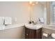 Cozy bathroom with a corner sink, dark wood cabinet, and a large mirror at 19131 E Crestridge Cir, Aurora, CO 80015