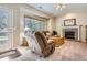 Cozy living room with a brick fireplace, a ceiling fan and ample natural light at 19131 E Crestridge Cir, Aurora, CO 80015