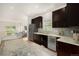 Open kitchen showcases stainless appliances, dark wood cabinetry, and mosaic backsplash, seamlessly connecting with the living area at 2935 S Sherman St, Englewood, CO 80113