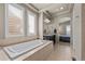 Luxurious bathroom boasting a soaking tub, plantation shutters, and access to the primary bedroom at 15230 W Baker Ave, Lakewood, CO 80228