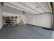Spacious garage with epoxy flooring, ample storage shelving, and an automatic door opener at 15230 W Baker Ave, Lakewood, CO 80228