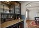 Close up of kitchen details, featuring granite countertops, dark cabinets, and a view into the dining area at 15230 W Baker Ave, Lakewood, CO 80228