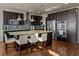 Gourmet kitchen featuring dark cabinetry, stainless steel appliances, and a large center island at 15230 W Baker Ave, Lakewood, CO 80228