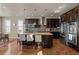 Spacious kitchen with a large center island, modern stainless steel appliances, and rich hardwood flooring at 15230 W Baker Ave, Lakewood, CO 80228