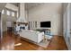 Bright living room with high ceilings, a stone fireplace, hardwood floors, and large windows at 15230 W Baker Ave, Lakewood, CO 80228