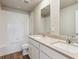 This bathroom features a double sink and vanity with a tub and shower at 48295 Shetland Dr, Bennett, CO 80102