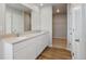 Modern bathroom featuring dual sinks, white cabinets, and a walk-in closet entrance at 48295 Shetland Dr, Bennett, CO 80102