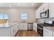 Modern kitchen featuring white cabinets, stainless steel appliances, and a bright window view at 48295 Shetland Dr, Bennett, CO 80102