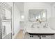 Well-lit bathroom with double sinks, towel warmer, and view of the glass shower with tiled walls at 562 N Pennsylvania St, Denver, CO 80203