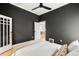 Bedroom with dark walls and white trim, featuring hardwood floors, white bedding, and a ceiling fan at 562 N Pennsylvania St, Denver, CO 80203