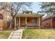 Charming brick home featuring a welcoming front porch with classic columns and a well-manicured lawn at 562 N Pennsylvania St, Denver, CO 80203