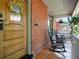Relaxing front porch with rocking chairs, wood flooring and brick wall creating a welcoming ambiance at 562 N Pennsylvania St, Denver, CO 80203