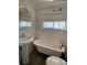 Bright bathroom features a classic clawfoot tub, pedestal sink, and natural light from a window at 2429 S Cherokee St, Denver, CO 80223