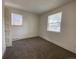 Clean bedroom featuring two bright windows, carpet floors, and fresh paint at 2429 S Cherokee St, Denver, CO 80223