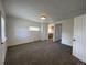 A brightly lit living room with fresh carpet, white walls and modern recessed lighting at 2429 S Cherokee St, Denver, CO 80223