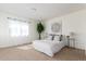 Bright bedroom with carpet and lots of light, features a white bed, plants and minimal furniture at 5722 S Addison Way # A, Aurora, CO 80016
