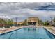 Community pool surrounded by lawn chairs with a small house next to it at 5722 S Addison Way # A, Aurora, CO 80016