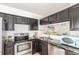 Stylish kitchen featuring stainless steel appliances and sleek black cabinetry at 5722 S Addison Way # A, Aurora, CO 80016