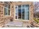 Covered patio with stone walls, door with dog access, and small bistro table at 5722 S Addison Way # A, Aurora, CO 80016