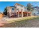 Backyard view of a beautiful home with a large deck, covered patio, and mature trees at 9554 E Hidden Hill Ln, Lone Tree, CO 80124