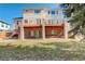 Backyard view of a beautiful home with a large deck, covered patio, and mature trees at 9554 E Hidden Hill Ln, Lone Tree, CO 80124