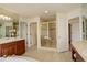 Bright bathroom featuring a tiled shower with glass door, dual vanities, and neutral tones at 9554 E Hidden Hill Ln, Lone Tree, CO 80124