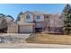 Charming two-story home featuring a three-car garage, and manicured landscaping on a sunny day at 9554 E Hidden Hill Ln, Lone Tree, CO 80124