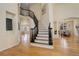 Elegant foyer showcasing hardwood floors, a staircase with iron railing, and views to living spaces at 9554 E Hidden Hill Ln, Lone Tree, CO 80124