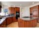 Kitchen with wood cabinets, granite countertops, island cooktop, and built-in oven at 9554 E Hidden Hill Ln, Lone Tree, CO 80124