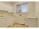 Clean laundry room with white cabinets, counter space, and a large window at 9554 E Hidden Hill Ln, Lone Tree, CO 80124