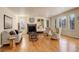 Bright living room boasting hardwood floors, a fireplace, built-in shelving and large windows at 9554 E Hidden Hill Ln, Lone Tree, CO 80124