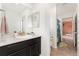 Bathroom features a vanity with dark wood cabinets, a white countertop, and double mirrors at 19316 W 84Th Pl, Arvada, CO 80007