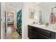 Bathroom features a vanity with dark wood cabinets, a white countertop, and double mirrors at 19316 W 84Th Pl, Arvada, CO 80007