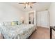 A bedroom showcasing a bed with a colorful paisley quilt and a view of a bathroom and closet at 19316 W 84Th Pl, Arvada, CO 80007