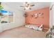 bedroom features a ceiling fan, a single bed, and a salmon colored accent wall with butterfly decals at 19316 W 84Th Pl, Arvada, CO 80007