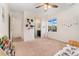 Bright bedroom features a ceiling fan, a window, and a view to the bathroom and hallway at 19316 W 84Th Pl, Arvada, CO 80007