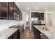 Modern kitchen with dark wood cabinets, granite countertops, and stainless steel appliances at 19316 W 84Th Pl, Arvada, CO 80007