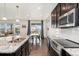 Eat-in kitchen featuring granite counters, modern appliances, and seamless flow to dining area at 19316 W 84Th Pl, Arvada, CO 80007