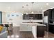 Modern eat-in kitchen with island, stainless steel appliances, and dark wood cabinets at 19316 W 84Th Pl, Arvada, CO 80007