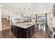 Open-concept kitchen with dark island, stainless steel appliances, and hardwood floors at 19316 W 84Th Pl, Arvada, CO 80007